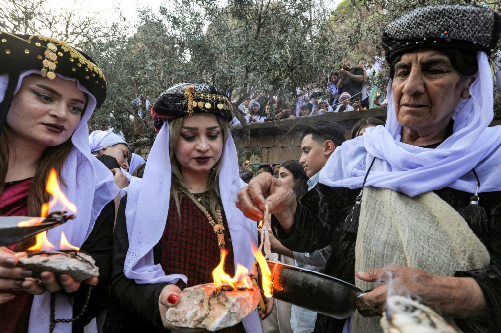 إيزيديون عراقيون يضيئون الشموع خلال حفل بمناسبة رأس السنة الإيزيدية (ا ف ب)   