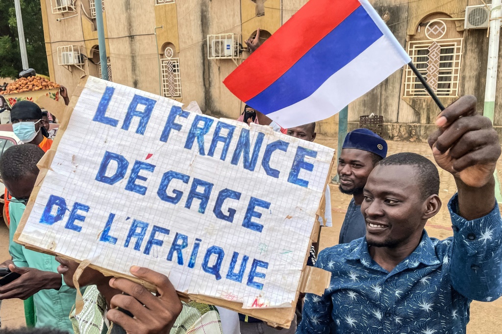 متظاهرون يرفعون لافتة منددة بفرنسا يوم عيد الاستقلال في نيامي في الثالث من آب/اغسطس 2023 (ا ف ب)