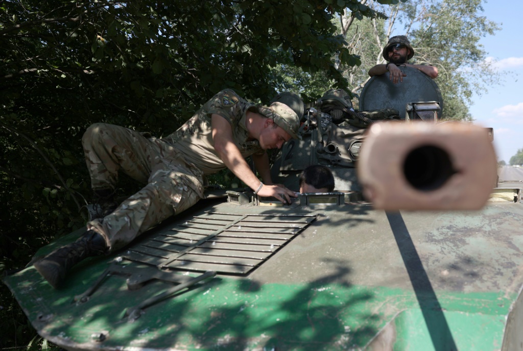جنود أوكرانيون يرتاحون على آلية عسكرية على طريق في منطقة دونيتسك في الثالث من آب/اغسطس 2023 (ا ف ب)
