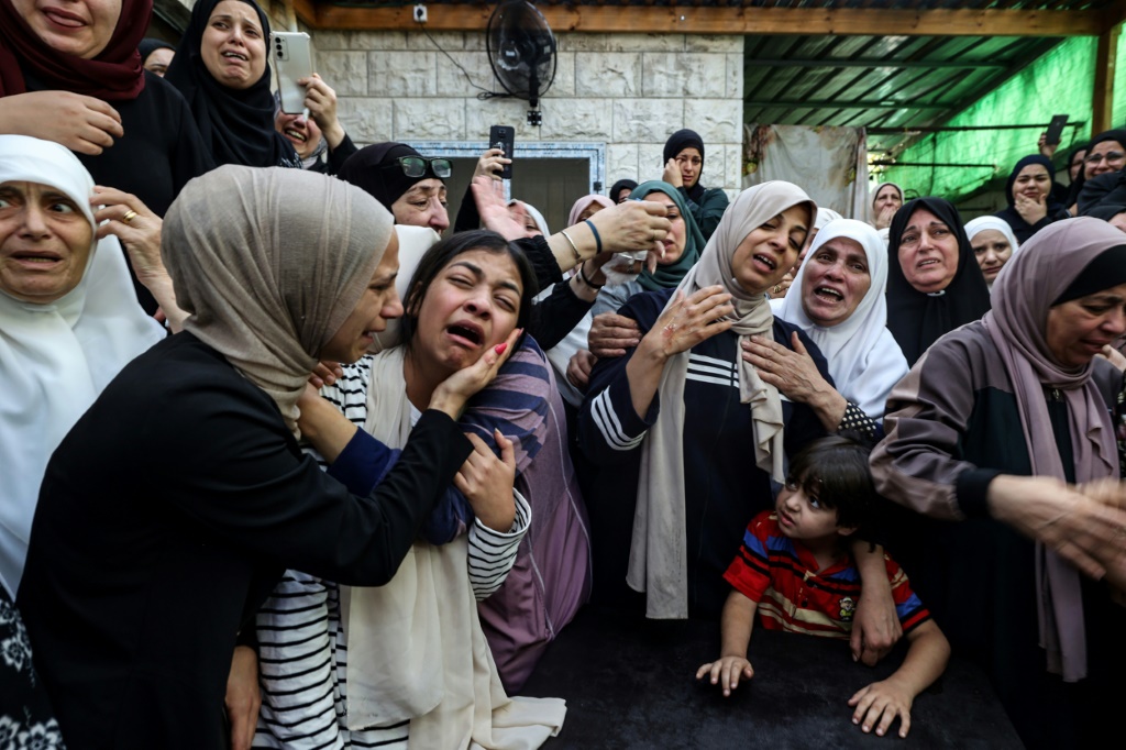 نساء يبكين في تشييع جنازة الفلسطيني محمود أبو صان (18 عاما) الذي استشهد برصاص القوات الإسرائيلية في الضفة الغربية المحتلة (أ ف ب)