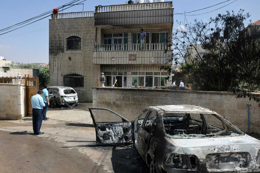 فلسطينيون يقفون قرب مركبات محترقة وسط تصاعد هجمات المستوطنين على قرية ترمسعيا الفلسطينية قرب رام الله في ضمال الضفة الغربية المحتلة في 21 حزيران/يونيو 2023 (أ ف ب)  &nbsp;