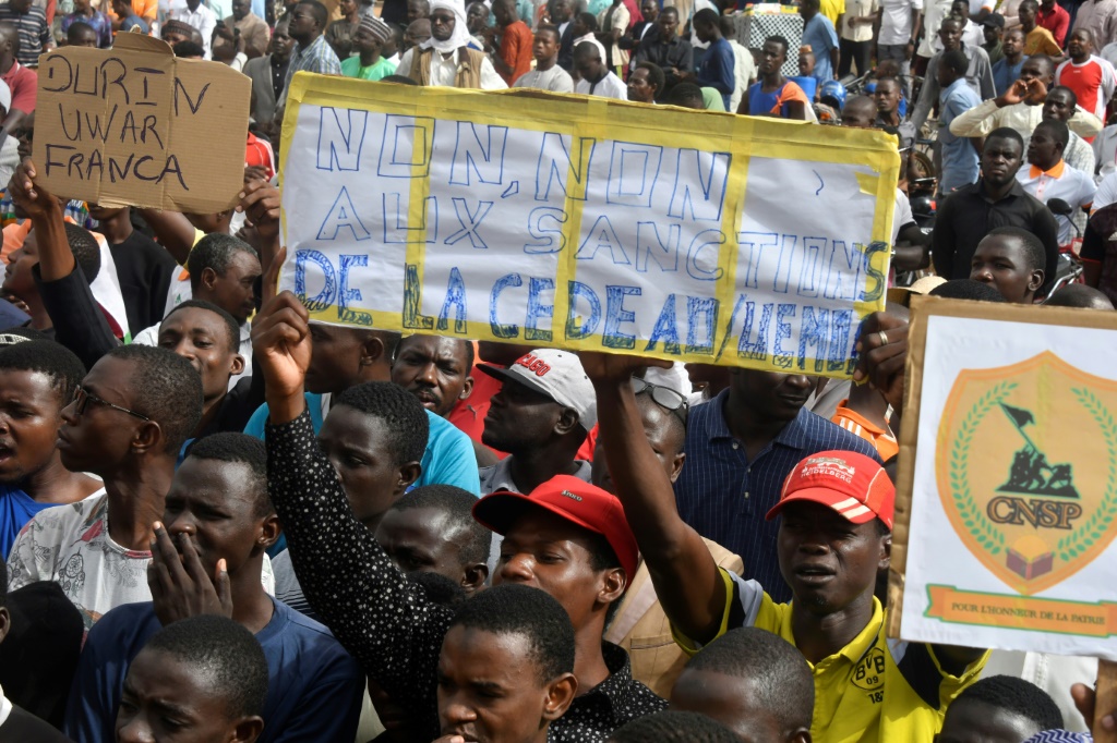 متظاهرون مؤيدون للانقلابيين العسكريين يحملون لافتة معارضة لمجموعة اكواس في 3 آب/اغسطس 2023 في نيامي (ا ف ب)