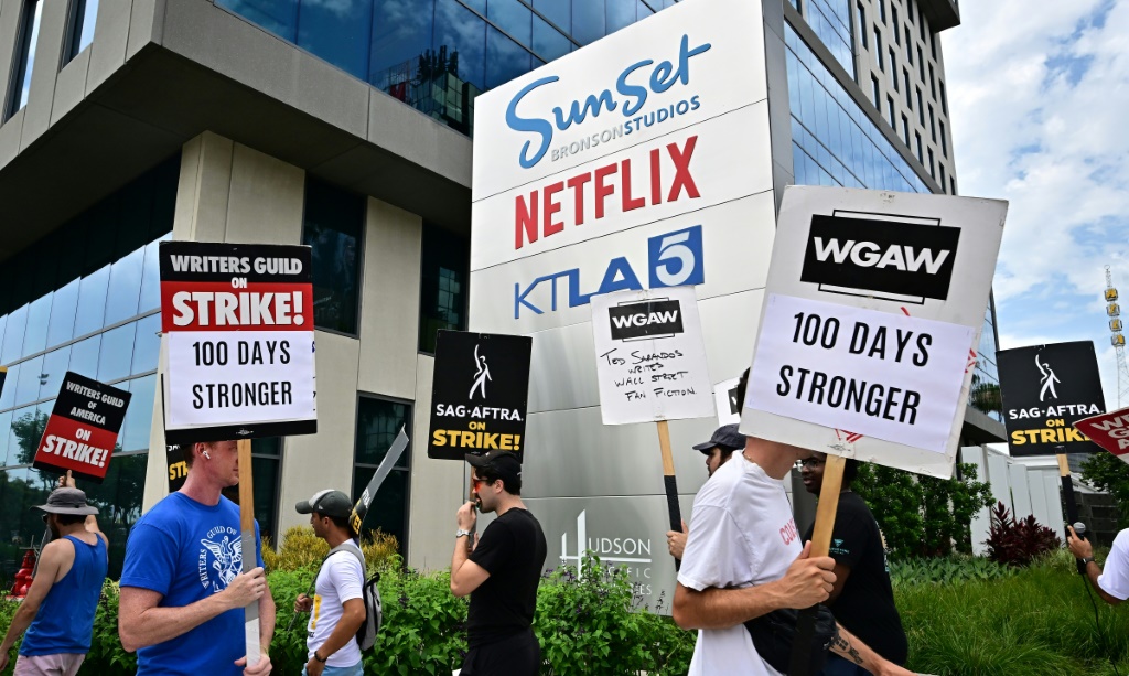 أعضاء في نقابتي كتّاب السيناريو والممثلين يتظاهرون أمام مكاتب نتفليكس في لوس أنجليس في التاسع من آب/أغسطس 2023 في اليوم المئة من إضرابهم (ا ف ب)
