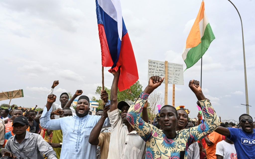 مؤيدون للانقلاب في النيجر يلوحون بالأعلام النيجرية والروسية قرب قاعدة عسكرية فرنسية في نيامي في 11 آب/أغسطس 2023 (ا ف ب)