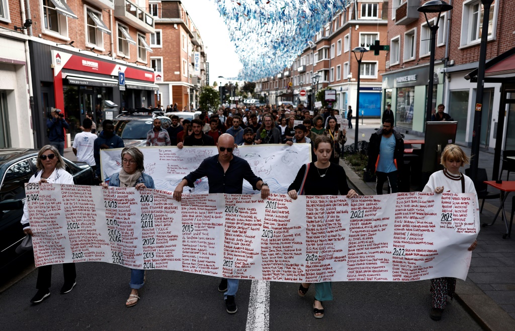وتجمع نحو 200 شخص يوم الأحد في كاليه على الميناء لتقديم التحية لمن لقوا حتفهم (أ ف ب)   