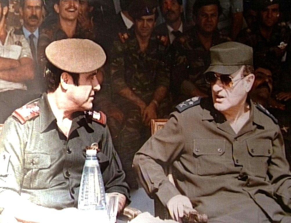 صورة من الأرشيف ملتقطة في الأول من كانون الثاني/يناير 1984 تظهر الرئيس السوري الراحل حافظ الأسد (يمين) إلى جانب شقيقه الأصغر رفعت الأسد (يسار)خلال مراسم عسكرية في دمشق (ا ف ب)