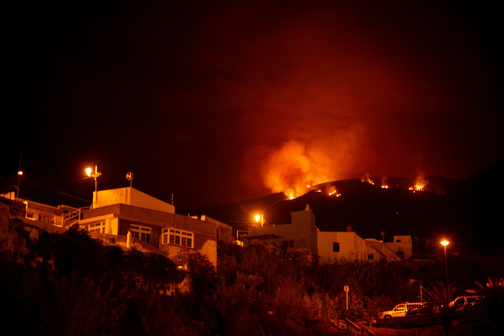صورة التقطت ليل 19 آب/أغسطس 2023 تُظهر حريقًا قريبًأ من منازل في وادي غيمار في جزيرة تينيريفي الإسبانية (أ ف ب)   