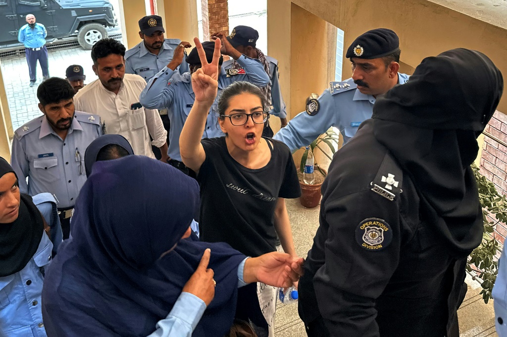     ضباط الشرطة يقدمون المحامي والناشط في مجال حقوق الإنسان إيمان مزاري حزير (وسط) إلى محكمة في إسلام أباد (أ ف ب)   