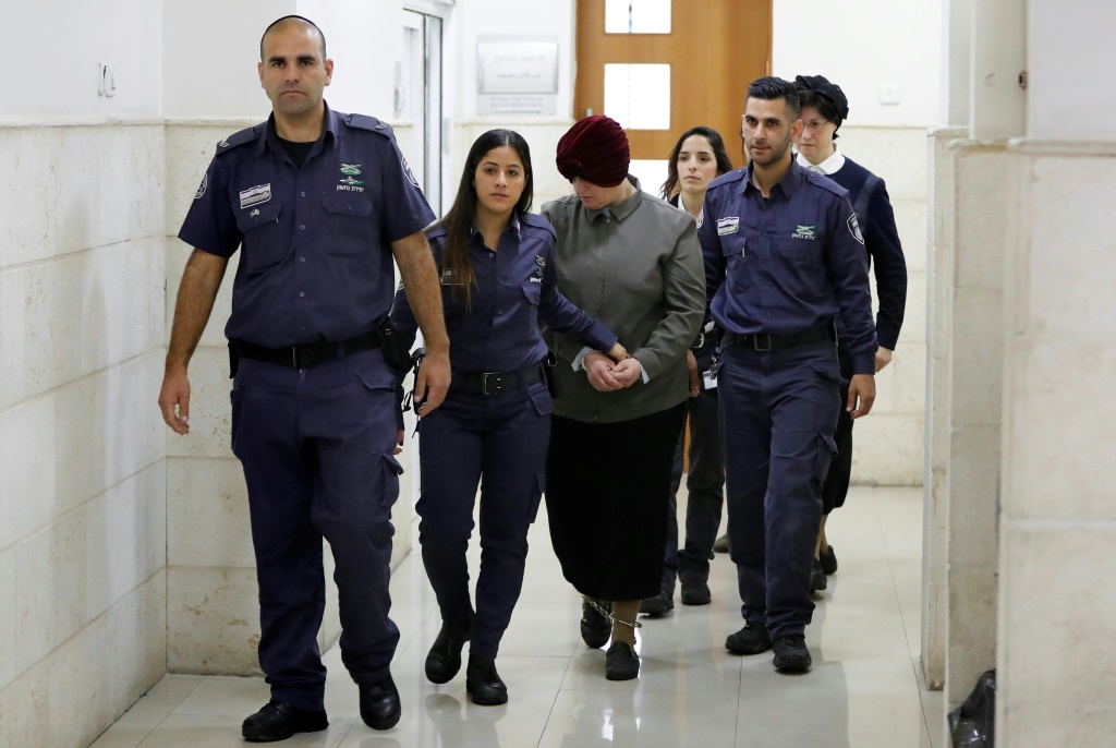 المدرّسة الأسترالية السابقة مالكا ليفر (وسط) بمواكبة شرطيين لدى وصولها إلى محكمة في القدس في 27 شباط/فبراير 2018 (ا ف ب)