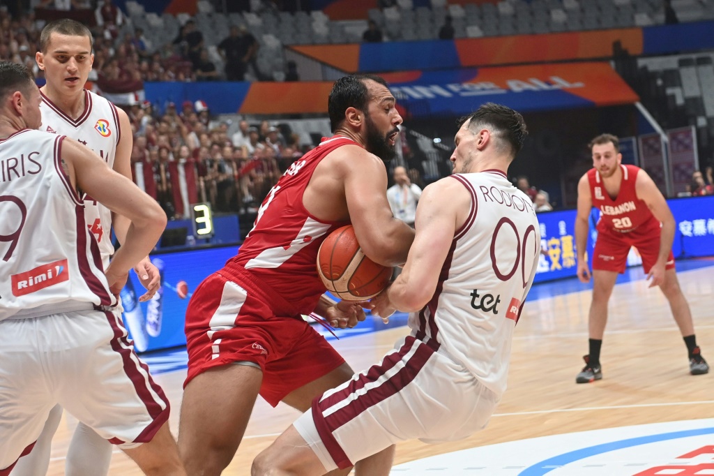 صراع على الكرة بين اللبناني علي حيدر (وسط) وروديونز كوروكس (يمين) من لاتفيا خلال المباراة التي جمعت المنتخبَين في المجموعة الثامنة لكأس العالم لكرة السلة في جاكرتا في 25 آب/أغسطس 2023. (ا ف ب)