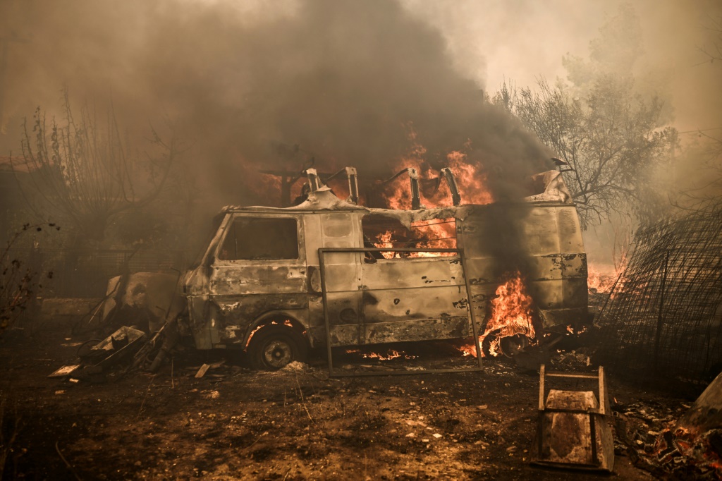 شاحنة صغيرة تشتعل لدى امتداد حرائق الغابات شمال العاصمة اليونانية أثينا في 23 آب/أغسطس 2023 (ا ف ب)