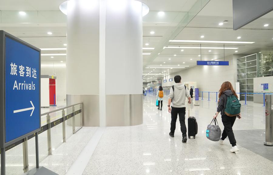 في الصورة الملتقطة يوم 8 يناير 2023، مسافرون وافدون يصلون إلى مطار شانغهاي بودنغ الدولي في شانغهاي شرقي الصين (شينخوا)