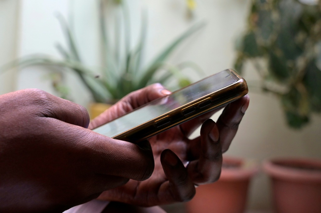 شخص يحمل هاتفًا محمولًا في دكار في التاسع من آب/أغسطس 2023 (ا ف ب)