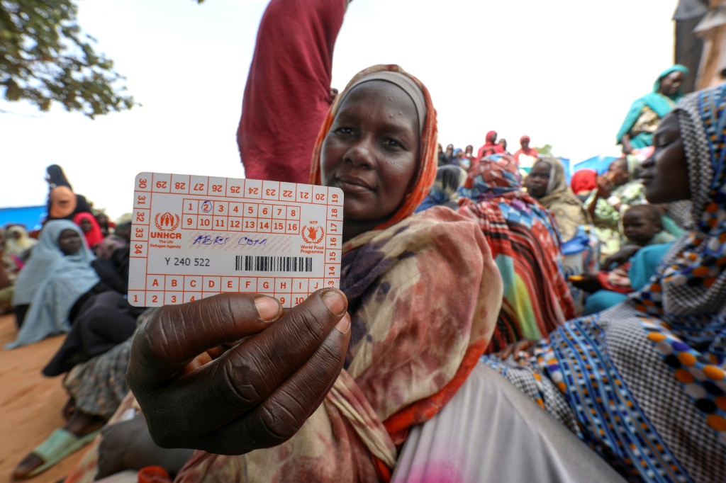 نساء فررن من الحرب في السودان ينتظرن توزيع حصص المساعدات الدولية في مخيم أورانغ للاجئين بالقرب من بلدة أدري في شرق تشاد في 15 آب/أغسطس 2023 (ا ف ب)