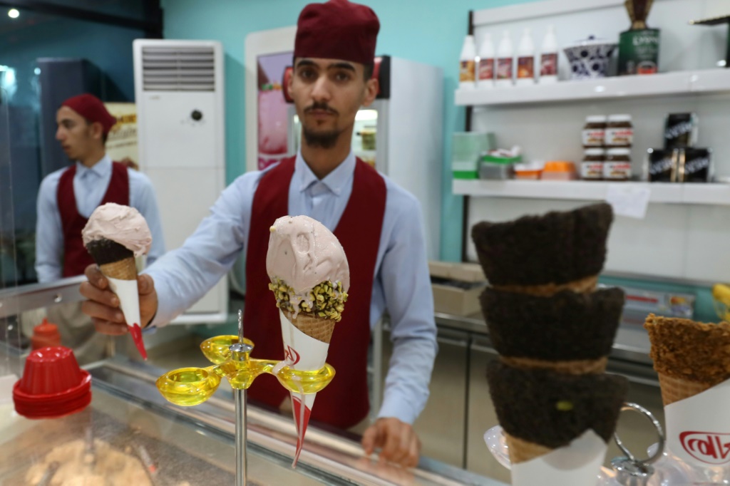 رجل يعد طلبية لزبون في متجر للمثلجات في العاصمة الليبية طرابلس في 23 تموز/يوليو 2023 (ا ف ب)