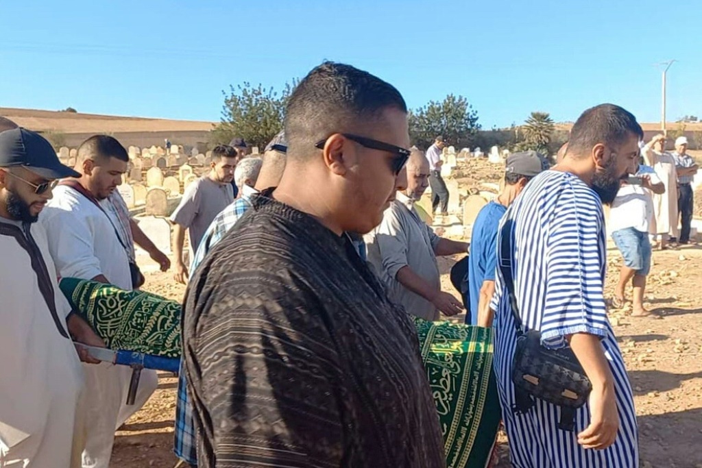  أقارب يحملون جثمان بلال كيسي خلال جنازته في السعيدية بالمغرب (أ ف ب)
