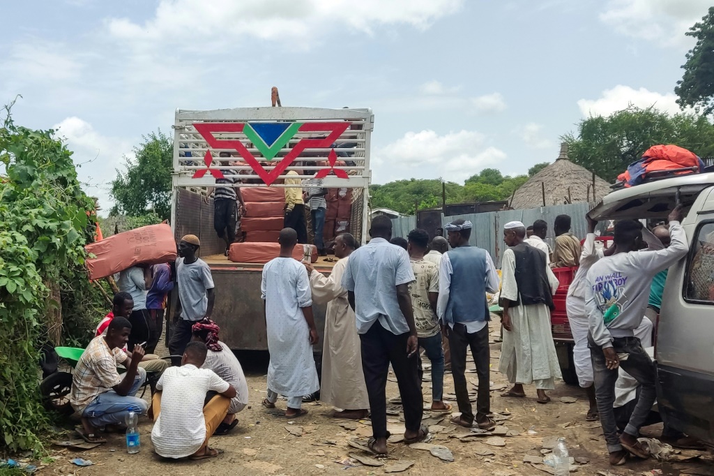    رجال يفرغون منتجات إثيوبية من شاحنة في بلدة القلابات الحدودية السودانية في 2 آب/أغسطس 2023 (أ ف ب)   