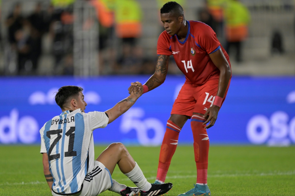 مدافع منتخب بنما خيلبرتو هرنانديس (يمين) يساعد مهاجم المنتخب الارجنتيني باولو ديبالا على النهوض خلال مباراة دولية ودية في كرة القدم. بوينوس أيرس، في 23 آذار/مارس 2023 (ا ف ب)