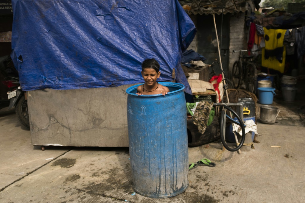 صورة التقطت في 3 ايار/مايو 2023 في نيودلهي يبدو فيها طفل داخل برميل ماء اتقاءً من الحر الشديد (ا ف ب)