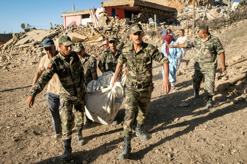 جنود مغاربة يقومون بإجلاء جثة في قرية تافغاغت التي دمرها الزلزال، في التاسع من أيلول/سبتمبر 2023 (ا ف ب)