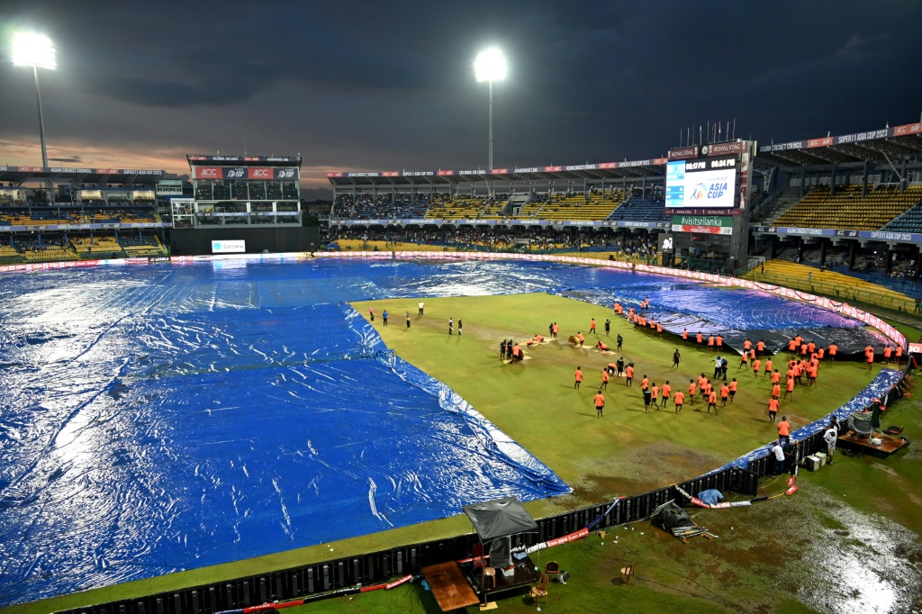 ألم المطر: قام طاقم العمل الأرضي بتغطية الملعب بعد توقف المطر عن اللعب خلال مباراة كأس آسيا بين الهند وباكستان (أ ف ب)   