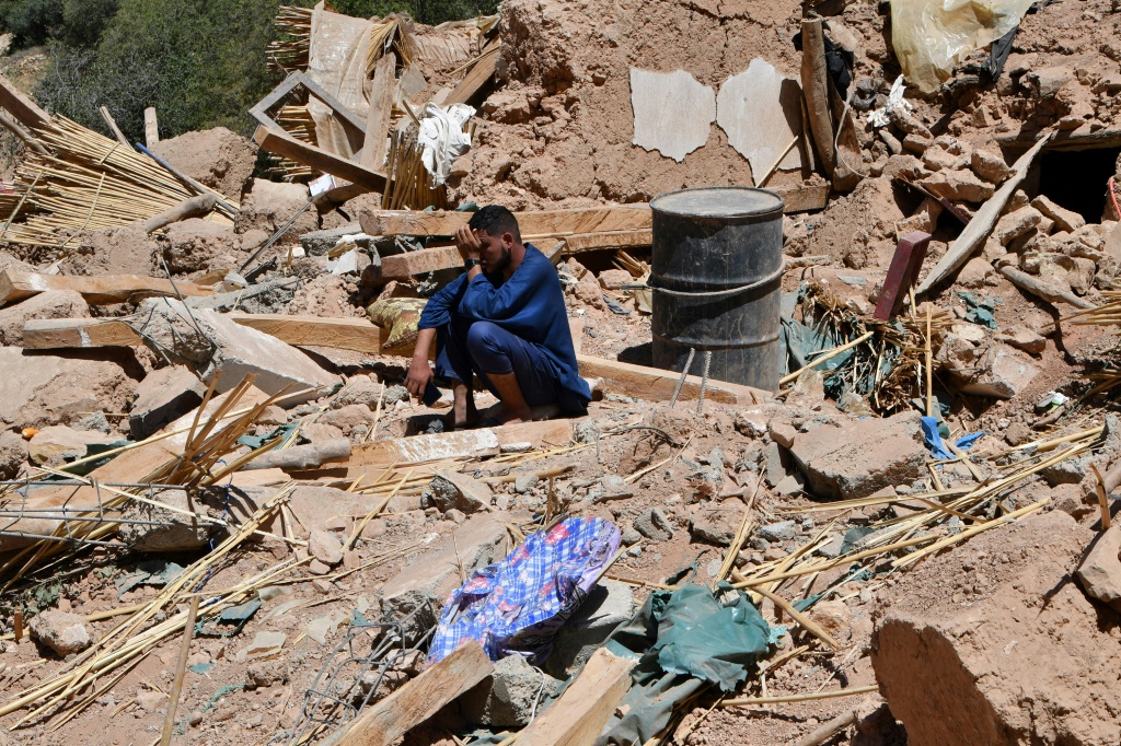رجل يبكي وهو جالس وسط أنقاض مشهد الدمار في قرية تيخت في 10 أيلول/سبتمبر 2023 بعد الزلزال الذي ضرب المغرب (ا ف ب)