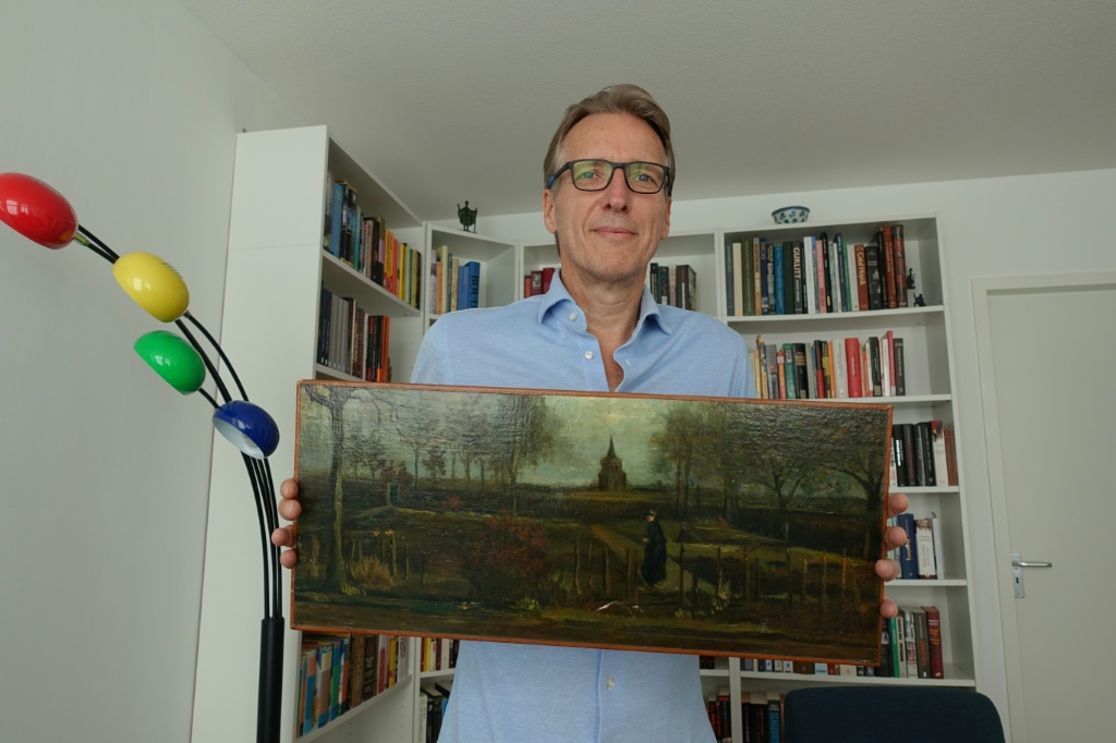 خبير الفنون الهولندي ارثر براند يحمل لوحة "حديقة القسيس في نيونيين في الربيع" للفنان فنسنت فان غوخ، في منزله في أمستردام في 11 أيلول/سبتمبر 2023 (ا ف ب)