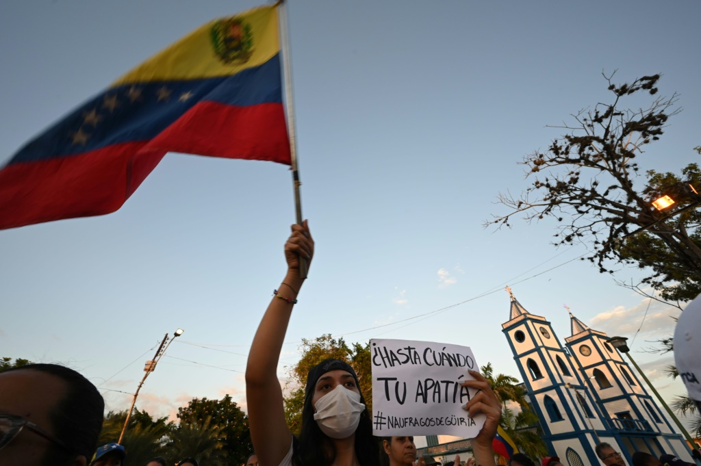 امرأة تلوّح بعلم فنزويلا خلال تظاهرة احتجاجية في مدينة غيريا في 17 كانون الأول/ديسمبر 2020 بعدما لقي 28 شخصاً حتفهم فيما كانوا يحاولون الهجرة في مركب إلى ترينيداد وتوباغو (ا ف ب)
