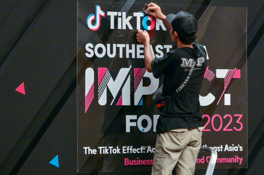 عامل ينهي اللافتة قبل منتدى تأثير تيك توك لجنوب شرق آسيا 2023 في جاكرتا في 15 يونيو 2023. (ا ف ب)   