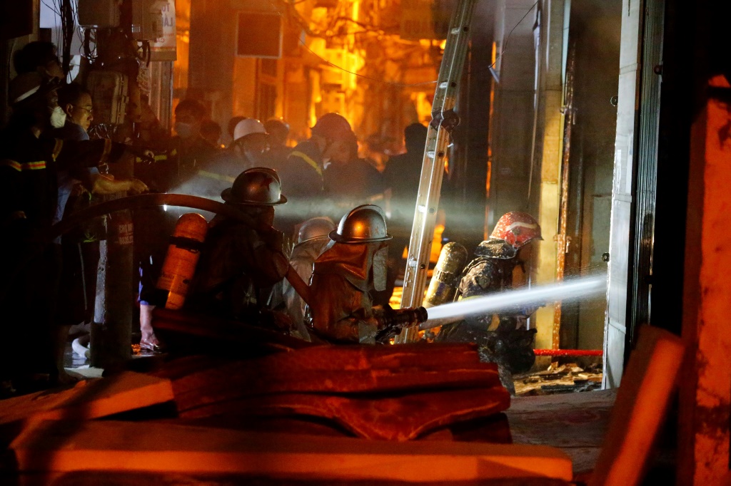 لقطة خلال محاولة رجال الإطفاء يعملون على إخماد حريق وإنقاذ الناس في مبنى سكني في هانوي (ا ف ب)