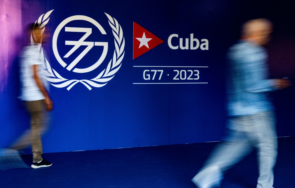    أشخاص يمرون من أمام لافتة تدل على قمة مجموعة77+الصين في هافانا بتاريخ 13 أيلول/سبتمبر 2023 (أ ف ب)   