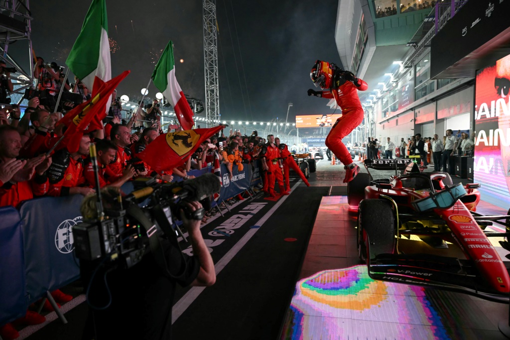 سائق فيراري الإسباني كارلوس ساينس محتفلاً مع الجماهير بإحرازه سباق جائزة سنغافورة الكبرى في 17 أيلول/سبتمبر 2023 (ا ف ب)
