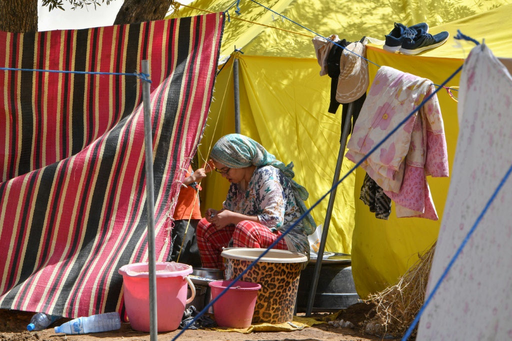 صورة مؤرخة في 16 أيلول/سبتمبر 2023 لامرأة تجلس أمام خيمتها في أمزميز المغربية (ا ف ب)