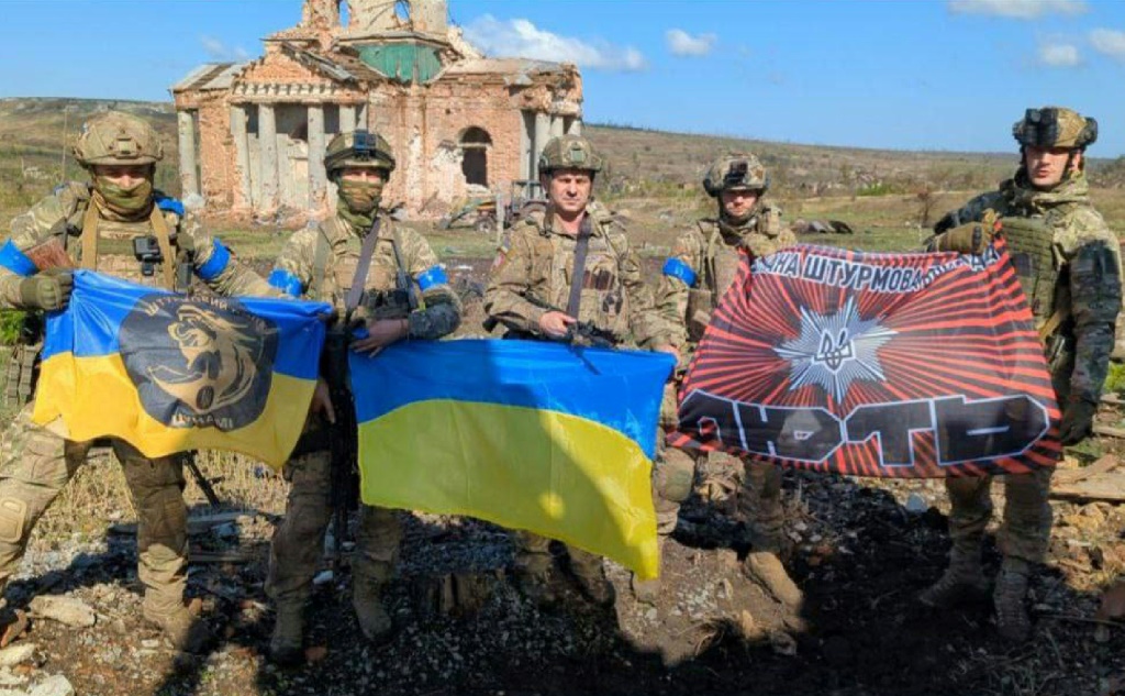 صورة مؤرخة في 17 أيلول/سبتمبر 2023 لجنود أوكرانيين أمام مبنى مدمر في كليشتشييفكا (ا ف ب)