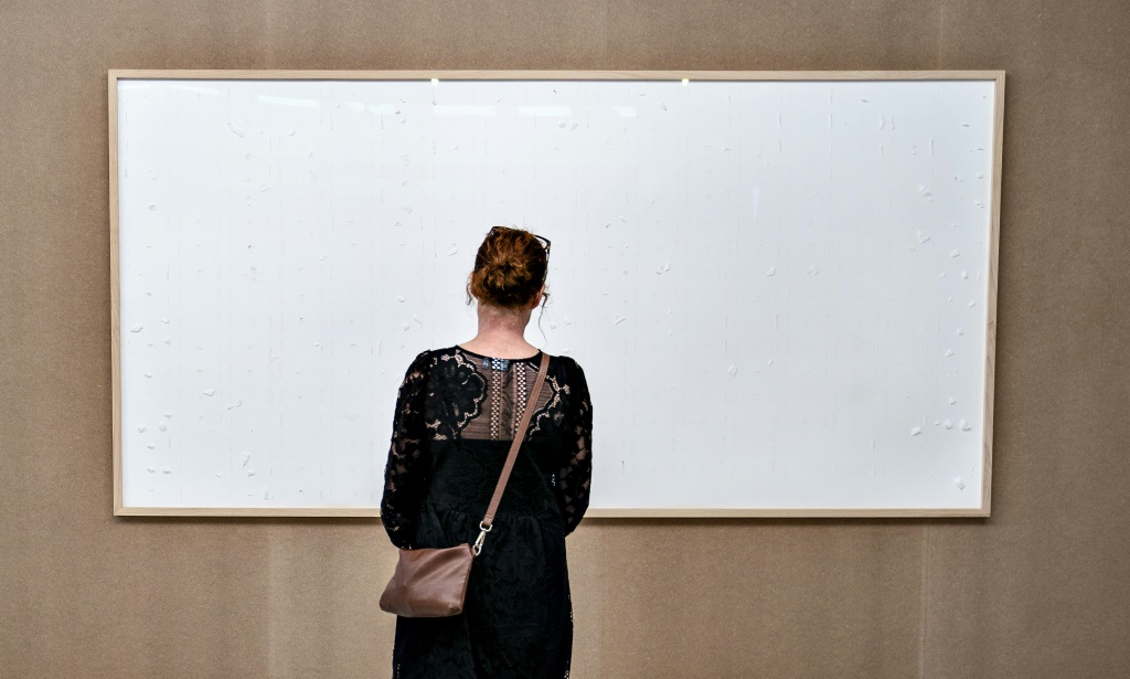 امرأة تقف أمام إطار فارغ معلق في متحف كونستن في مدينة ألبورغ الدنماركية في 28 أيلول/سبتمبر 2021 (ا ف ب)
