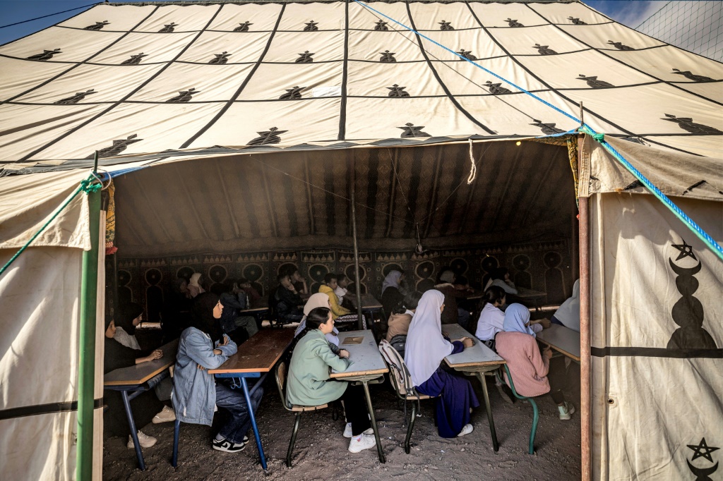 طلاب يحضرون دروسًا تحت خيمة في مدرسة مؤقتة في بلدة آسني التي ضربها الزلزال في محافظة الحوز بالمغرب في 18 أيلول/سبتمبر 2023 (أ ف ب)   
