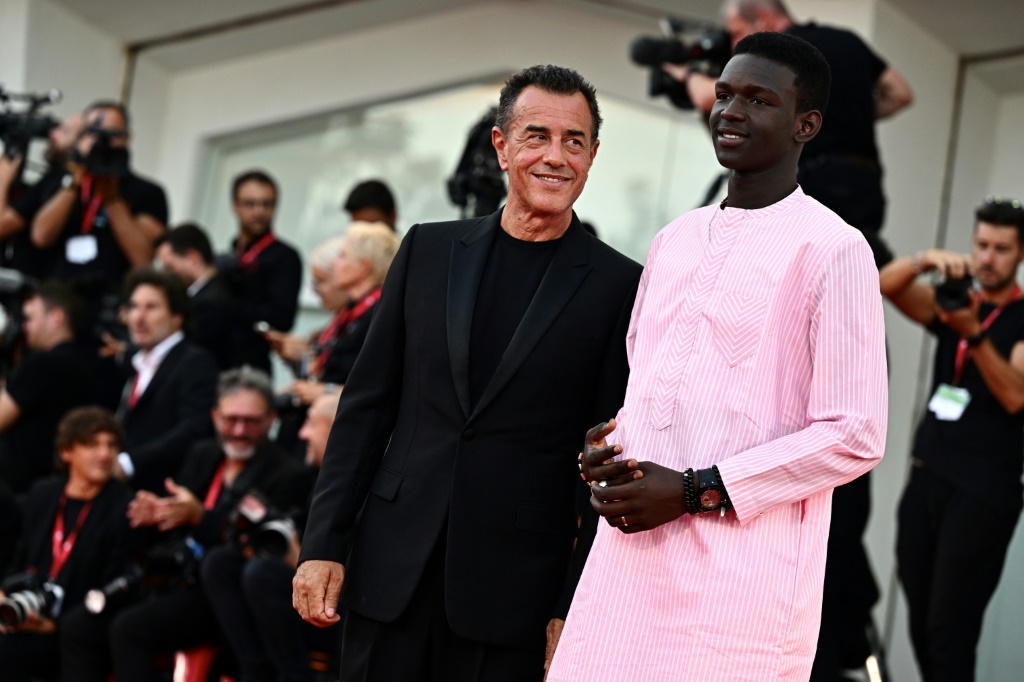 المخرج الإيطالي ماتيو غاروني (إلى اليسار) والممثل السنغالي سيدو سار لدى مرورهما على السجادة الحمراء في الحفلة الختامية للدورة الثمانين لمهرجان البندقية السينمائي في 9 أيلول/سبتمبر 2023 (ا ف ب)