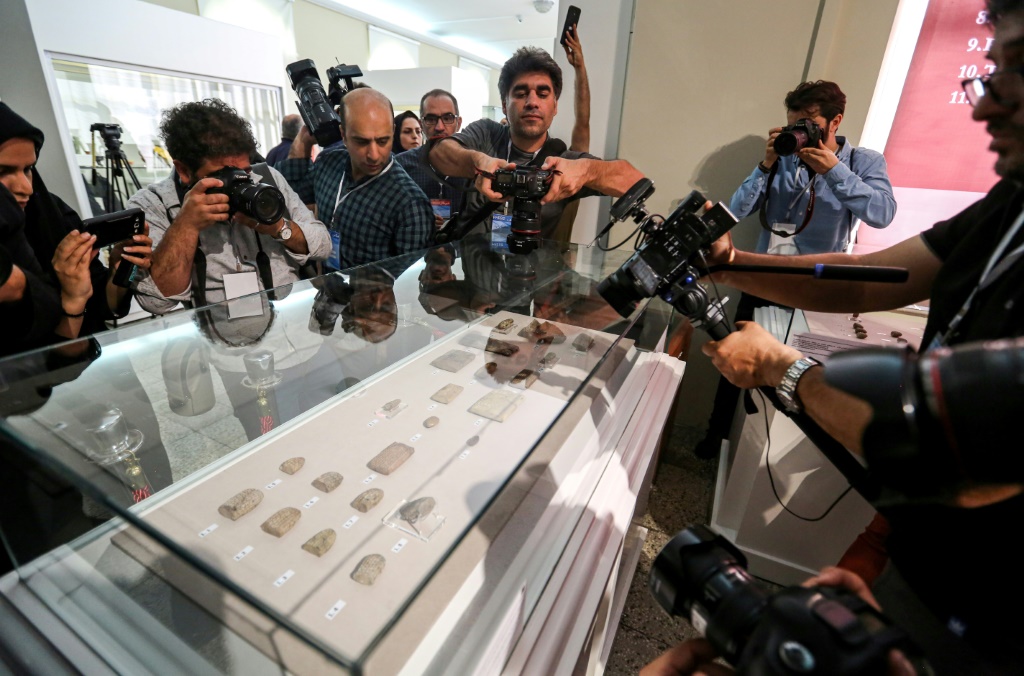 صحافيون يصورون الألواح الأثرية المستعادة من الولايات المتحدة وهي معروضة في المتحف الوطني الإيراني في 2 تشرين الأول/أكتوبر 2019 (ا ف ب)