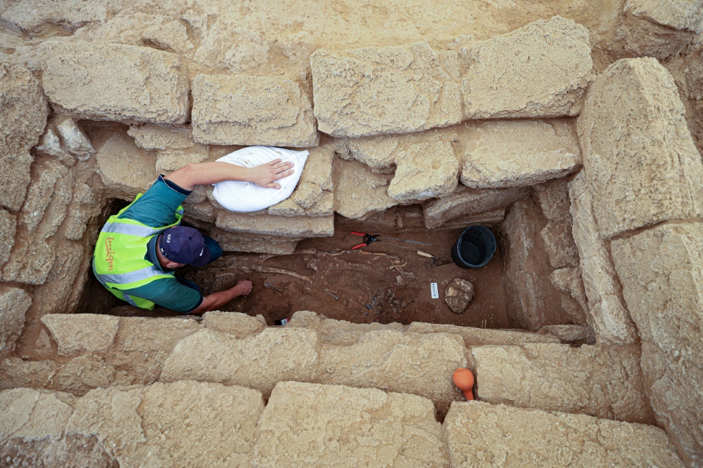 عالم آثار يستخرج في 23 ايلول/سبتمبر 2023 هيكلاً عظمياً بشرياً من موقع مقبرة أثرية من العصر الروماني في بيت لاهيا بشمال قطاع غزة (ا ف ب)