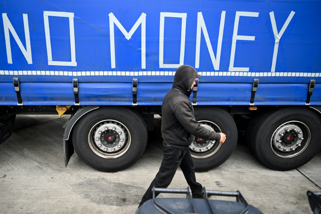 سائق يمر من أمام شاحنة كتب عليها "لا أملك المال" على أطراف فرانكفورت بتاريخ 22 أيلول/سبتمبر 2023 (أ ف ب)   
