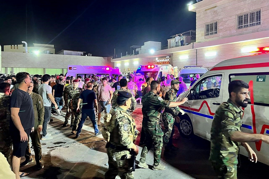 جنود ومسعفون يتجمعون حول سيارات الإسعاف التي تحمل المصابين في حريق حفل الزفاف العراقي (ا ف ب)