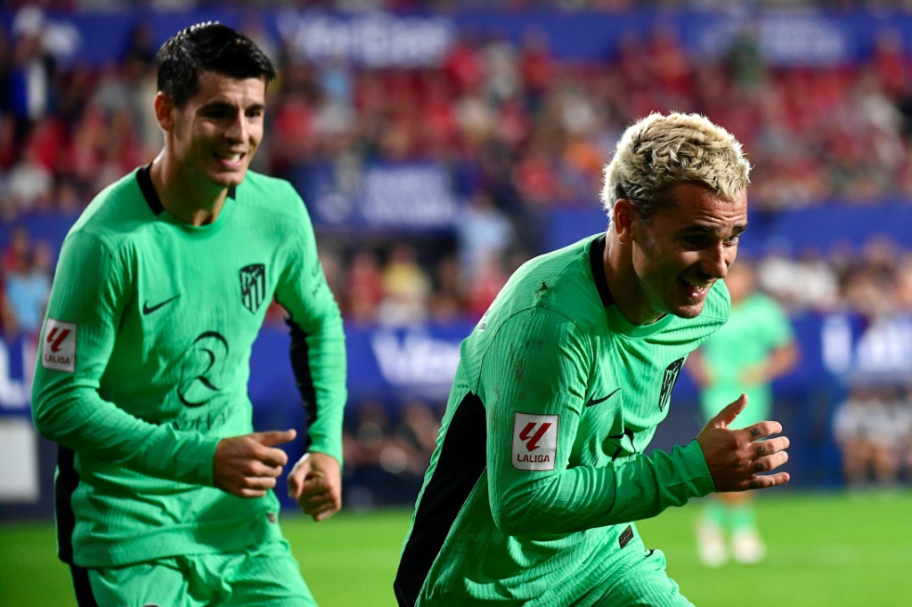  مهاجم أتلتيكو مدريد الفرنسي أنطوان غريزمان (إلى اليمين) وبدا خلفه زميله ألفارو موراتا يحتفل بافتتاحه التسجيل في مرمى أوساسونا على ملعب السادار في بامبلونا في 28 أيلول/سبتمبر 2023 (ا ف ب)