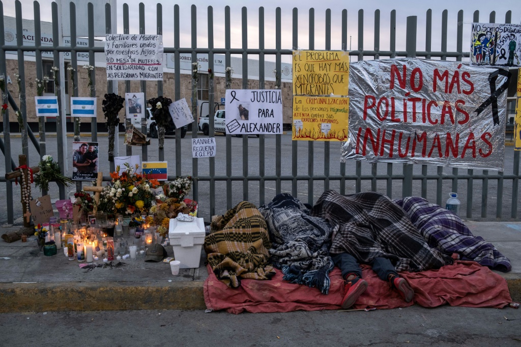 مهاجرون ينامون بجوار مذبح مؤقت خارج مركز احتجاز مكسيكي حيث توفي 40 مهاجرًا في حريق في مارس 2023 (أ ف ب)   