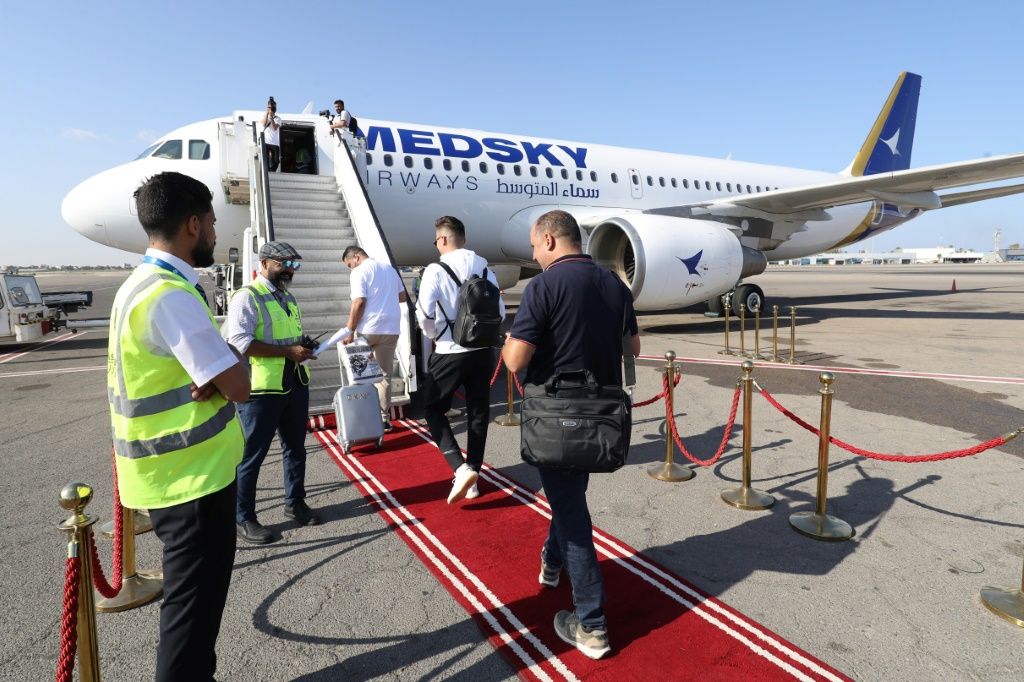 ركاب يغادرون على متن أول رحلة من طرابلس إلى روما في 30 أيلول/سبتمبر 2023 بعد أن رفعت الحكومة الإيطالية الحظر الجوي المفروض منذ 10 سنوات على الطيران المدني الليبي (أ ف ب)   