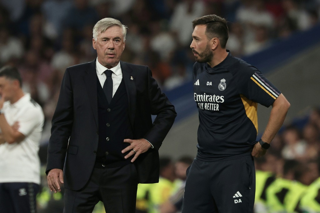 المدرب الايطالي لريال مدريد كارلو أنشيلوتي يتحدث الى مساعده نجله دافيدي خلال المباراة ضد لاس بالماس في الدوري الاسباني في 27 أيلول/سبتمبر 2023 (ا ف ب)
