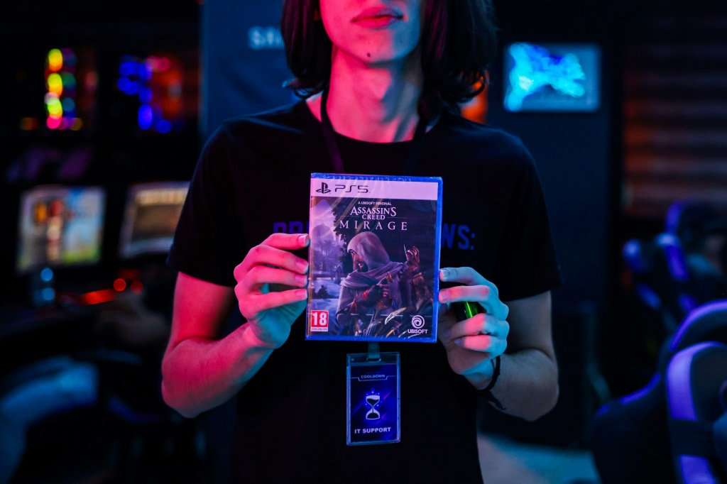 شاب يحمل النسخة الجديدة من لعبة أساسنز كريد في مقهى في بغداد في 4 تشرين الأول/أكتوبر 2023 (ا ف ب)