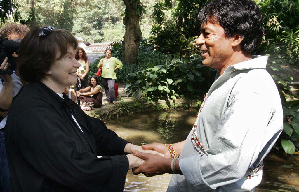 الكاتب أيلتون كريناك (إلى اليمين) مصافحاً دانييل ميتران، زوجة الرئيس الفرنسي الراحبل فرنسوا ميتران، خلال الاحتفال باليوم العالمي للمياه في الحديقة النباتية في ريو دي جانيرو بالبرازيل في 22 آذار/مارس 2007 (ا ف ب)