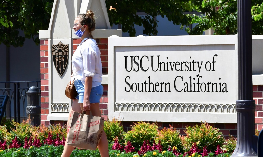 امرأة تمشي بجانب لافتة لجامعة جنوب كاليفورنيا في لوس أنجليس في 25 آب/أغسطس 2020 (ا ف ب)