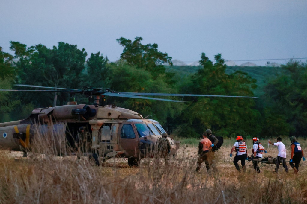 عناصر إنقاذ إسرائيليون يقومون بإجلاء رجل جريح بالقرب من بلدة سديروت في جنوب إسرائيل، 7 تشرين الأول/أكتوبر، 2023 (ا ف ب)