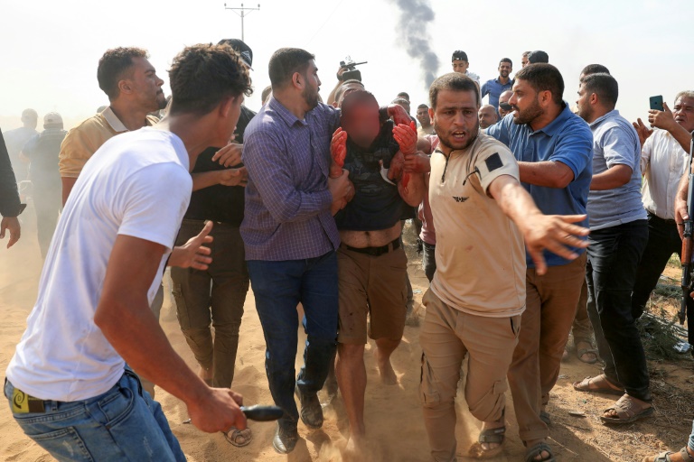 فلسطينيون يقتادون اسرائيليا جريحا في خان يونس بقطاع غزة في السابع من تشرين الاول/اكتوبر 2023 (أ ف ب)